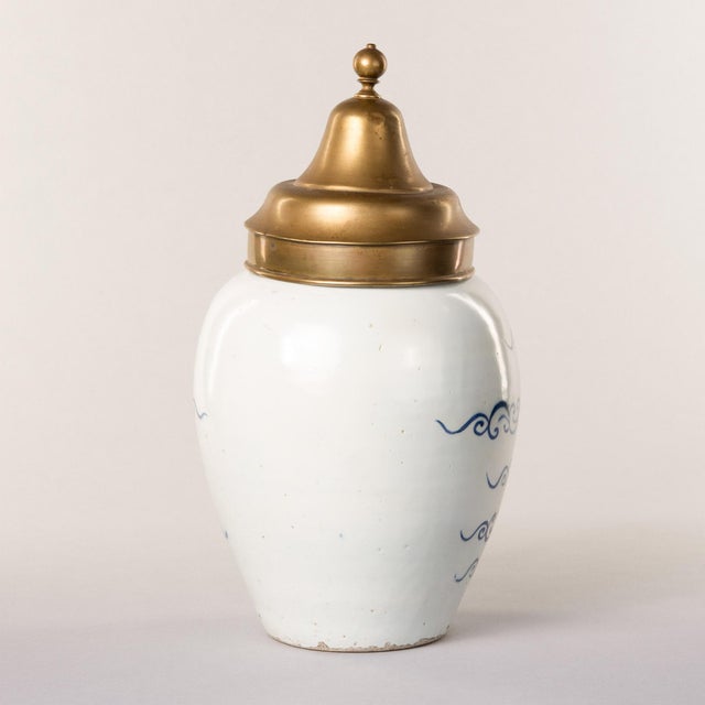 A rare and collectible example of Dutch Delftware craftsmanship, this tobacconist jar bears the inscription "St. Omer"...