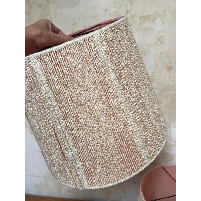 A pair of pale pink lined off white nubby textured yarn drum shades. 12.5” tall x 15.25” diameter. The last photo shows...