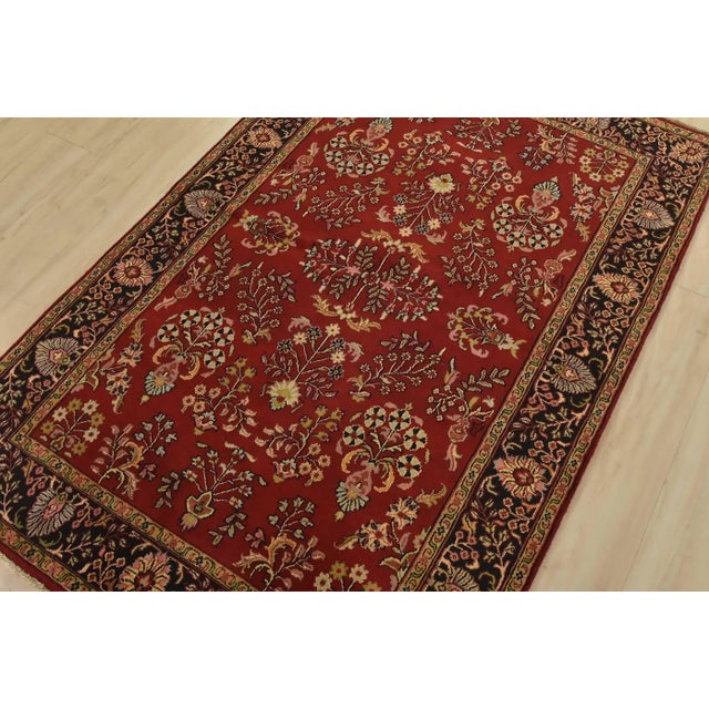 A traditional Sarouk rug hand-knotted with an all-wool pile on a cotton foundation. This finely woven oriental rug...