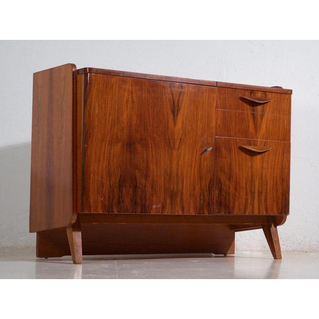 Vintage asymmetric sideboard veneered in walnut and raised on splayed legs, made in czechoslovakia around 1960. A mid-...