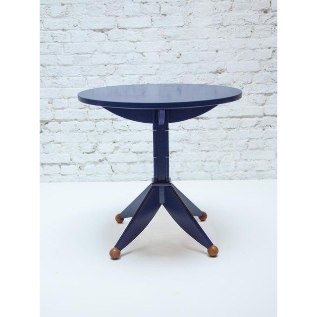 A striking round pedestal side table crafted from wood and finished in a deep navy blue lacquer. It features a unique...