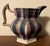Antique 19th century Staffordshire rainbow sponge ware pitcher in red, white and blue stripes. Hexagonal shape. Measures 6...