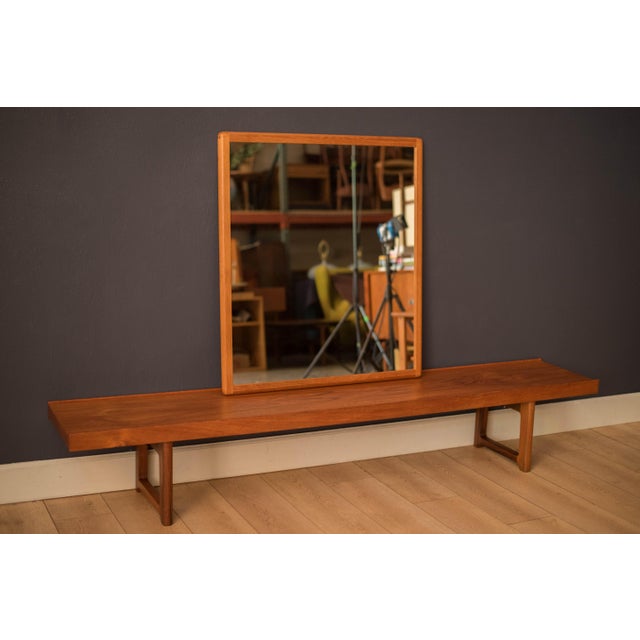 Mid century modern large hanging wall mirror in teak circa 1960's. This decorative accent piece displays natural wood...