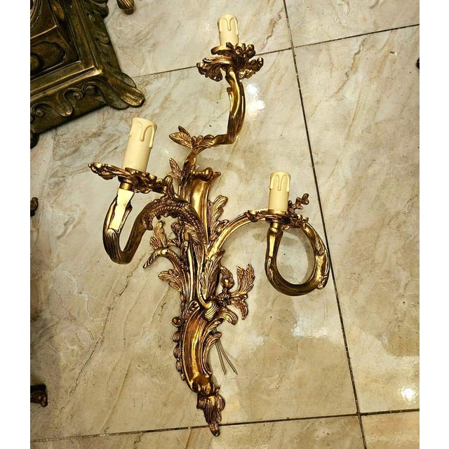 Make a dramatic statement with this exquisite French Rococo-style wall sconce, featuring three elegantly curved candle...