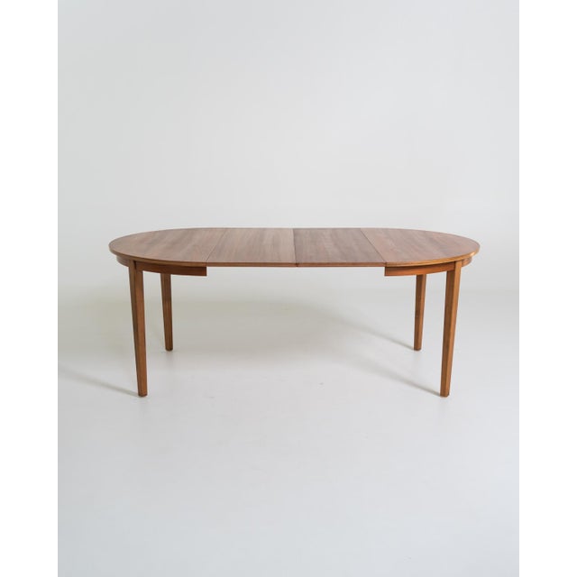 Round teak table with two central extensions and four square legs. Scandinavian production, 1960s. Made in Scandinavia in...