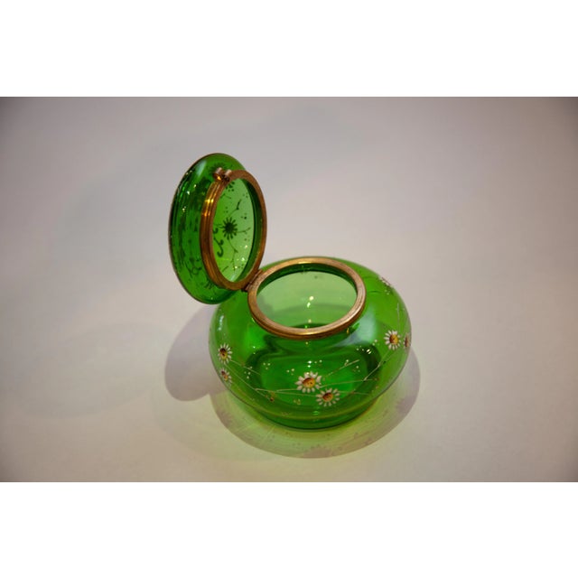 Moser Style Jar with Hinged Lid. Green glass with white and gold enamel flowers. A having yellow center metal around top...