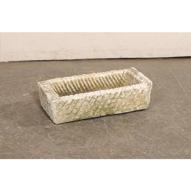 A Spanish carved stone basin or planter from the 19th century. This antique trough from Spain, has a rectangular shape...