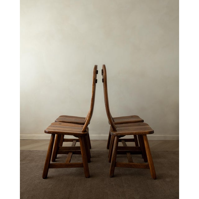 A vintage set of 4 brutalist dining chairs in solid oak, made by de puydt and produced in belgium during the 1960s–1970s....