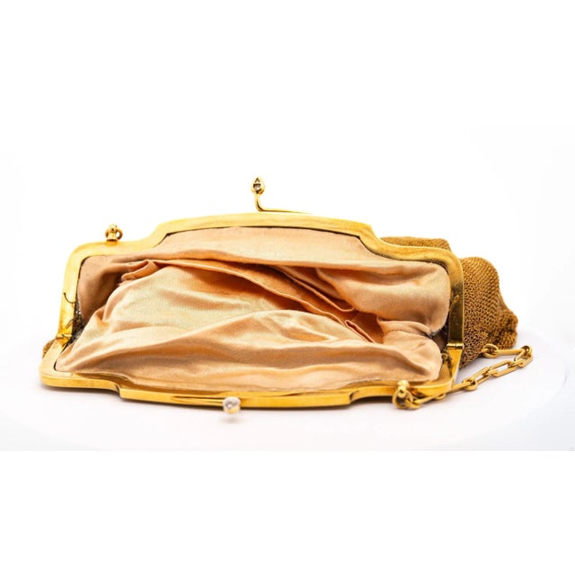 Offered is an exceedingly rare and coveted 18 Karat Gold Art Deco evening bag with a diamond and emerald frame. A...