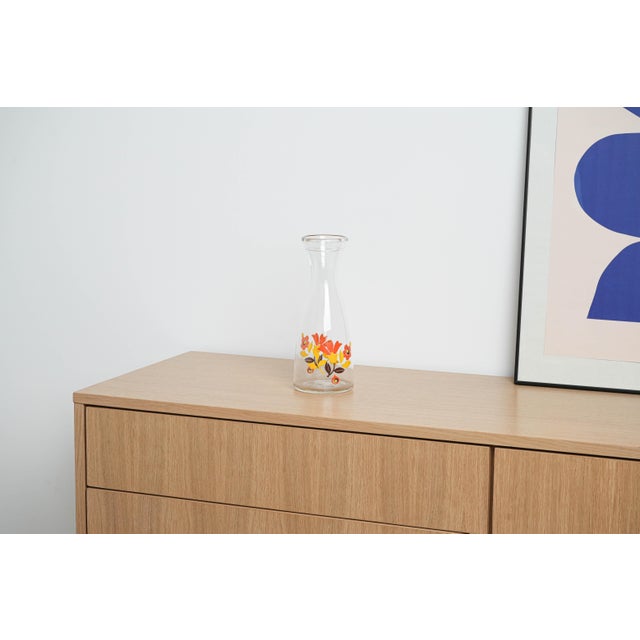 The carafe was made in the 1970s in Italy. A glass carafe with a wide spout and colourful retro-style print – red, yellow...