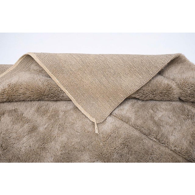 Monochromatic hand-knotted wool rug in Taupe, adorned with a subtle organic line pattern that adds quiet elegance and...