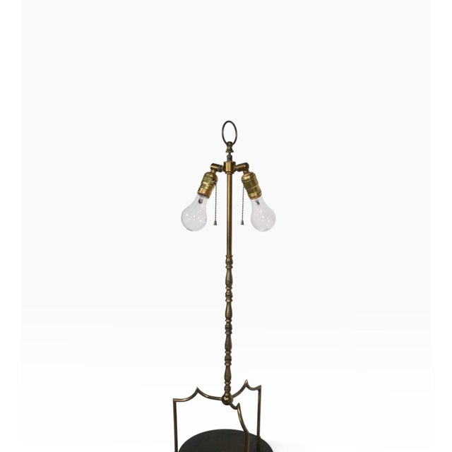 Elegant Hollywood Regency three tier shelf, floor lamp. The lamp features a stylized tubular brass frame, with solid wood...