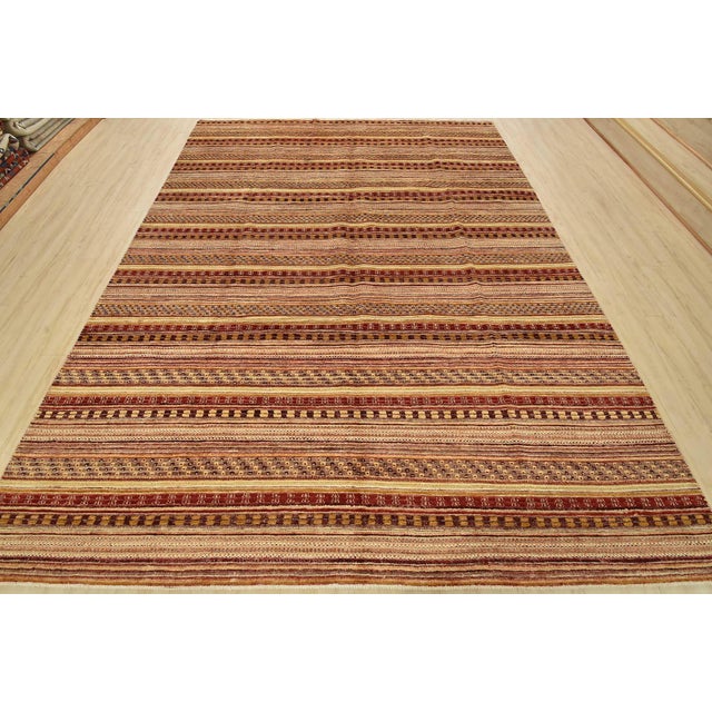 A contemporary Gabbeh rug hand-knotted with fine wool on a cotton foundation. This area rug features stripes embedded with...