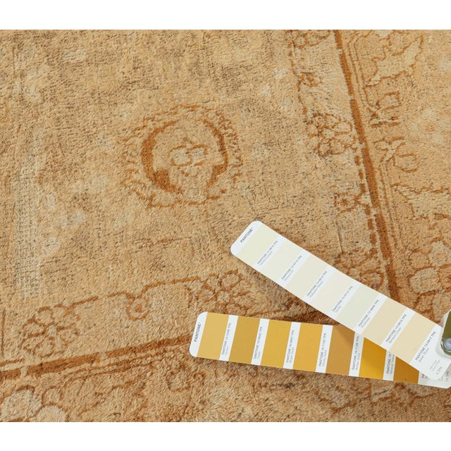 An early 20th century Indian Amritsar carpet, the camel field with a faint allover palmette and vinery trellis with...