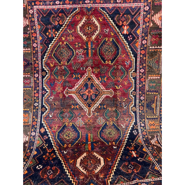 This extraordinary hand-knotted wool area rug showcases a traditional Persian Qashqai tribal style. The dramatic center...