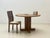 A striking round vintage dining table made of oak, likely from the 1970s. The design combines a solid, sculptural...