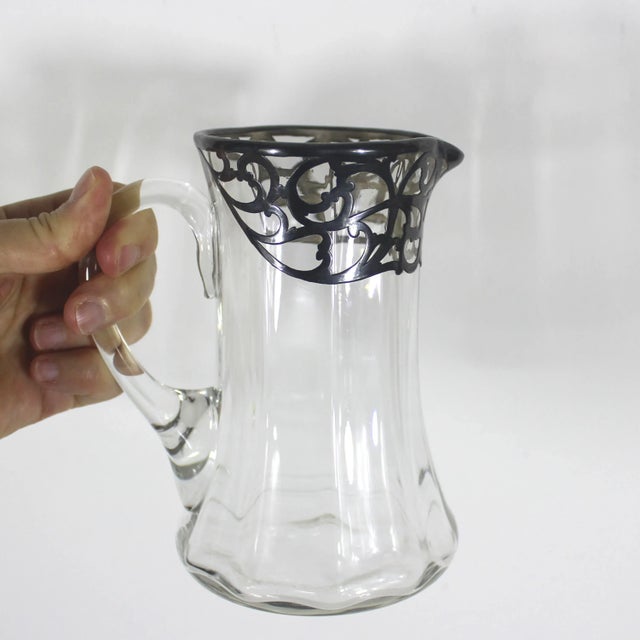Beautiful glass pitcher with silver overlay. Would look fabulous on your bar cart to hold mixed cocktails. The silver is...