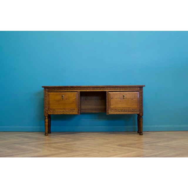 This beautifully carved 19th-century oak side table features two pull-down cupboards, each with two drawers.