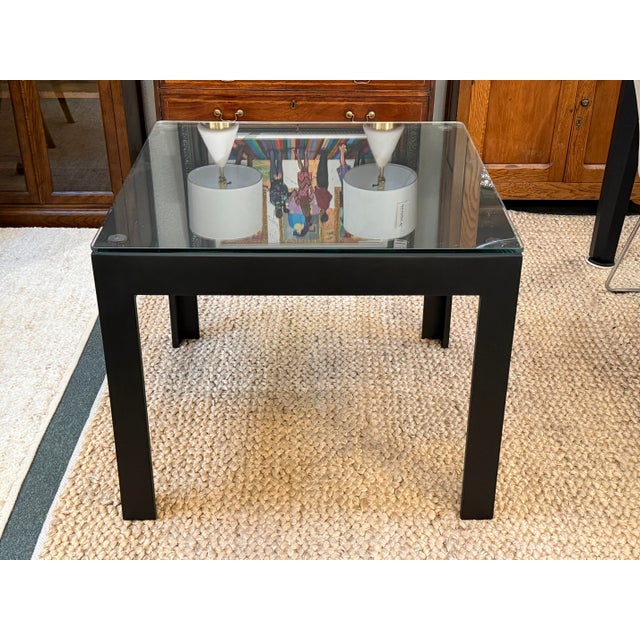 Design Plus Gallery presents a Parsons Style Metal + Glass Dining Table. The sleek and modern glass top table has a clean-...