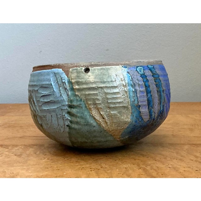 This vintage studio pottery bowl is a masterwork of textural exploration and artisanal craftsmanship. Its robust, hand-...