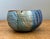 This vintage studio pottery bowl is a masterwork of textural exploration and artisanal craftsmanship. Its robust, hand-...