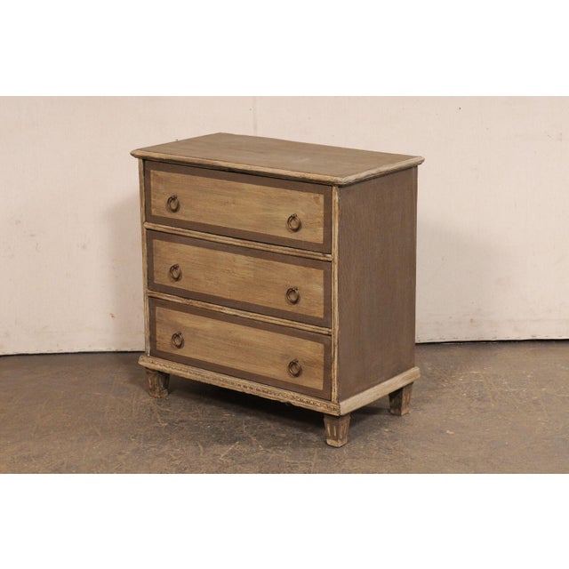 A smaller-sized English painted wood chest of three drawers, from the 18th century. This antique chest from England has...