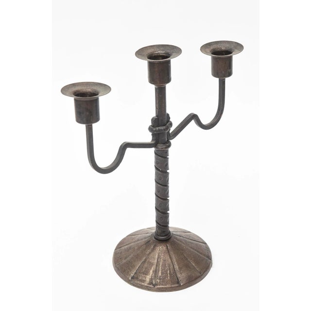 This very early Austrian signed arts and crafts bronze candlestick has 3 arms. It dates from the early 1900's. It is...