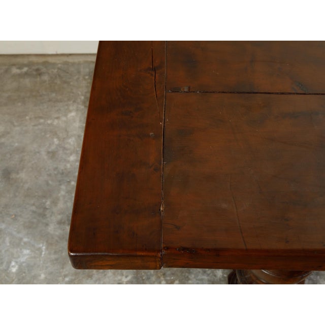 An English walnut dining table from the 19th century, with turned legs and H-Form cross stretcher. Created in England...