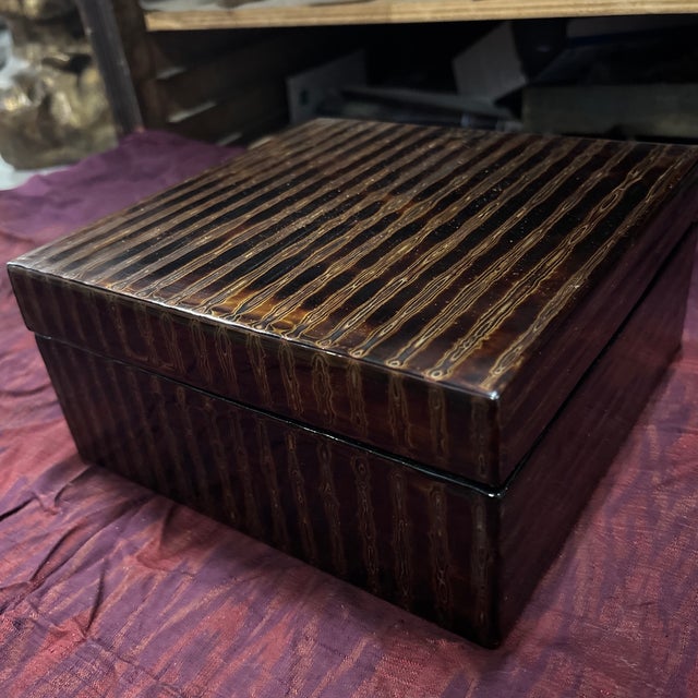 A supremely elegant black lacquer box with lid, decorated with delicate gold lines to create an organic alternating...