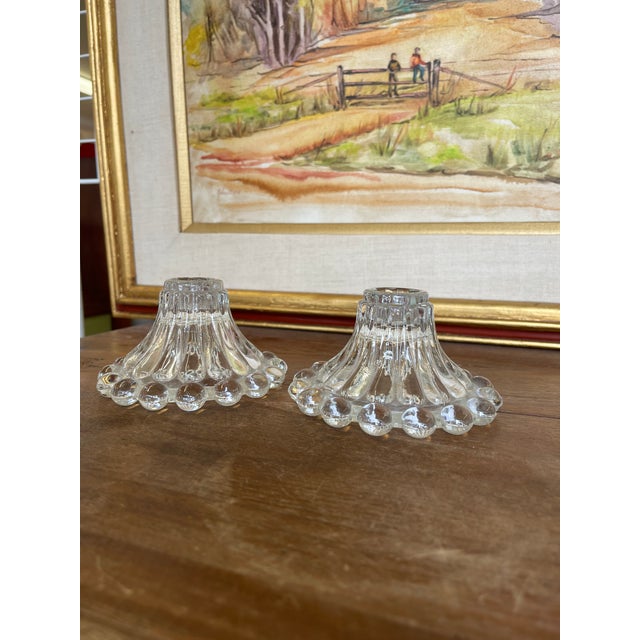 This set of two vintage clear glass candle holders features a sculptural, flared silhouette with a distinctive hobnail-...
