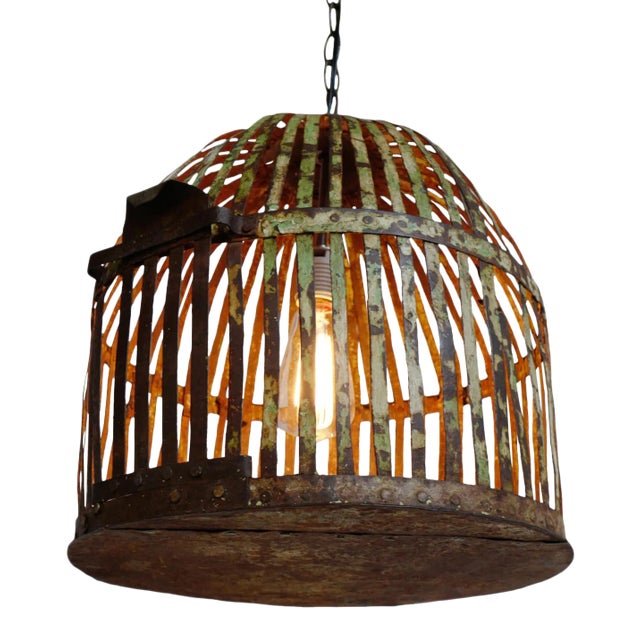 Vintage Indian iron cage basket thoughtfully repurposed into a one-of-a-kind pendant light, celebrating the raw beauty of...