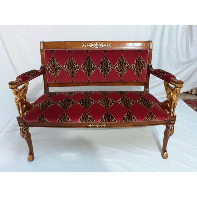 Carved maple sofa decorated in gold leaf and upholstered in brindle velvet with red diamonds.