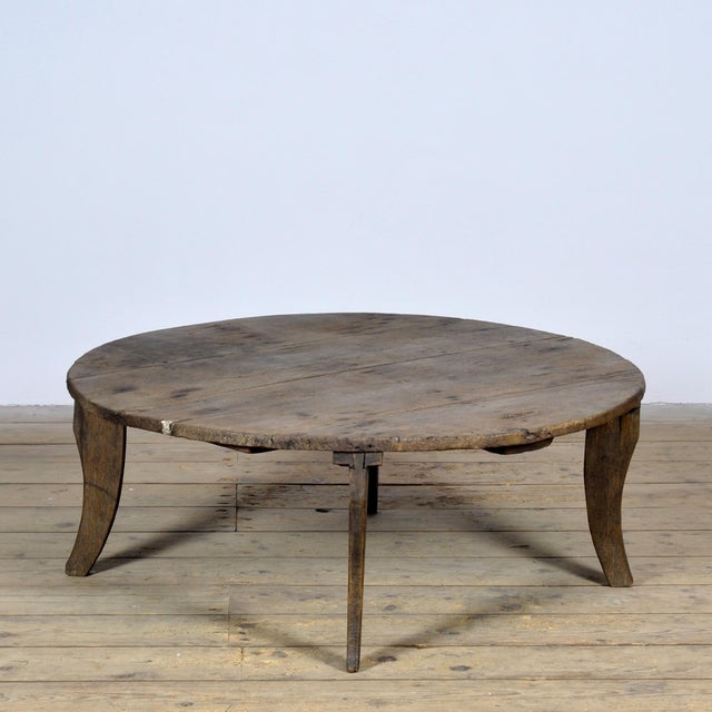 This small coffee table dates from circa 1920 and is made of solid pine. The round top consists of wide, weathered planks...