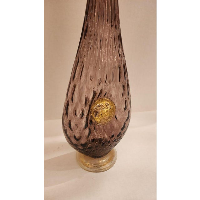 This listing features a Murano style vintage amethyst and gold decanter with a lion head with a gold raindrop shaped...