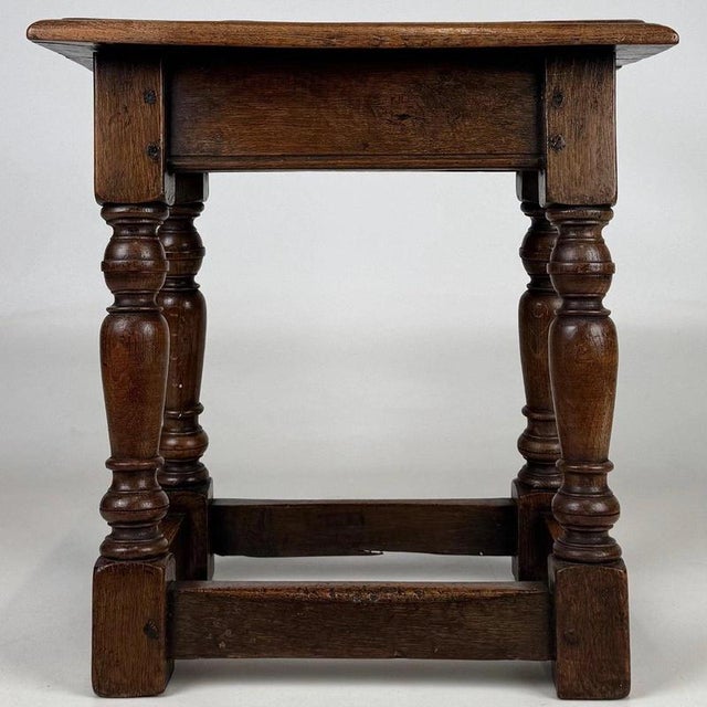 A charming 19th-century English joined stool, finely crafted from oak and distinguished by its traditional pegged...
