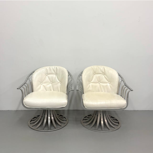 A striking pair of vintage Woodard swivel lounge chairs featuring sculptural cast aluminum frames with gracefully arched...