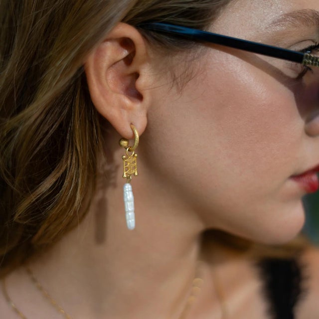Bring divine elegance and mystical charm to your style with the Isis Pearl Talisman Dangle Earrings. Inspired by the...