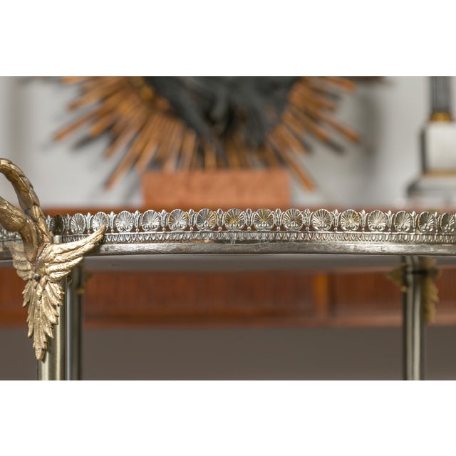 A vintage Italian steel and bronze round top side table from the mid-20th century with two doors, swan necks and wing...