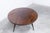 A 1960s tripod coffee table in varnished mahogany. The tabletop is clean and has a beautiful varnished finish. There are a...