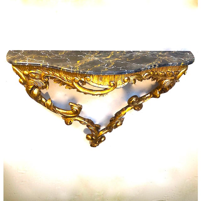 Antique hand-carved console table . Water gilding over gesso. Faux marble painted top. Unmarked and sans any label - we...