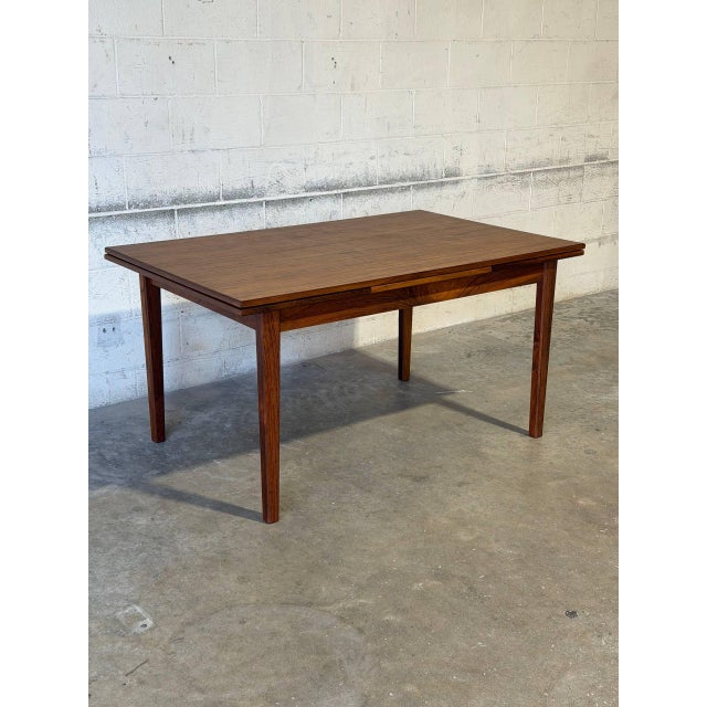 This beautiful expandable dining table features a minimalist rectangular top profile supported by sleek square tapered...