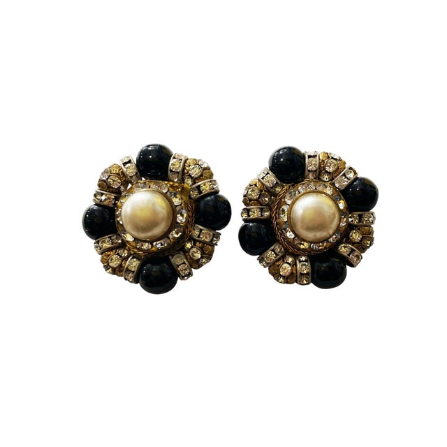 These vintage mid-century gold tone clip-on earrings feature a stunning cluster of round faux pearls in black and beige,...