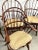 This set of 4 custom Windsor armchairs includes cushions for added comfort. The chairs are fully assembled in a brown...