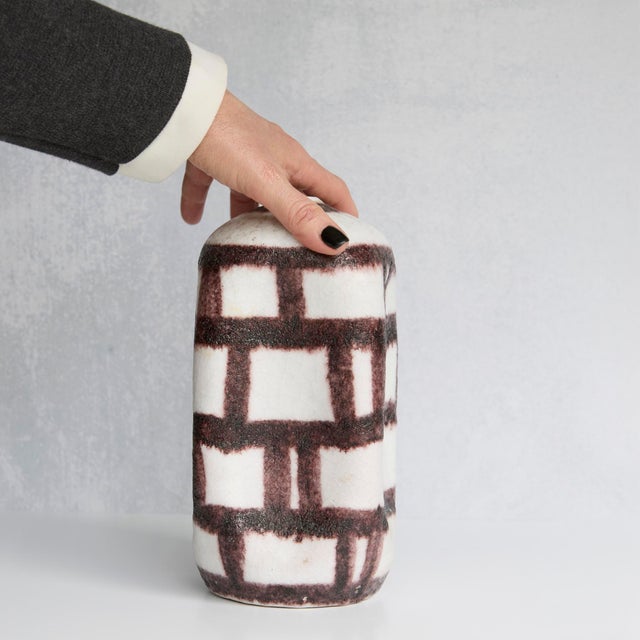 A striking signed Guido Gambone vase, where disciplined geometry meets the unmistakable warmth of the handmade. Its softly...