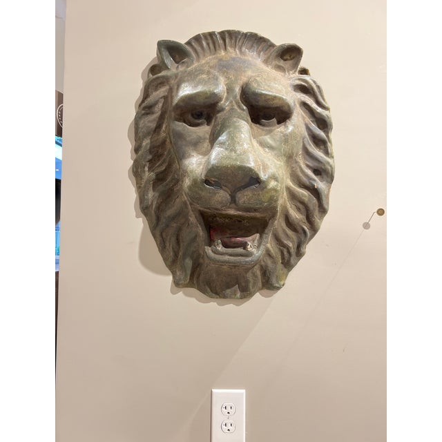 A commanding pair of vintage lion head plaques, each cast in a richly patinated metal with verdigris and bronze hues....