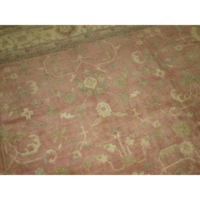 A square-shaped antique Turkish Oushak with accents of mint and cream on a salmon colored field. 11'10'' x 12'6''