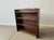 A free-standing open fronted vintage bookcase with 4 shelves. The two end supports taper towards the top. Made from dark...