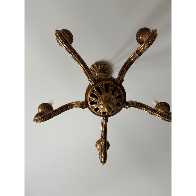A beautifully crafted six-light carved chandelier by Paul Ferrante, finished in a warm hand-applied antiqued gilt. Rich...