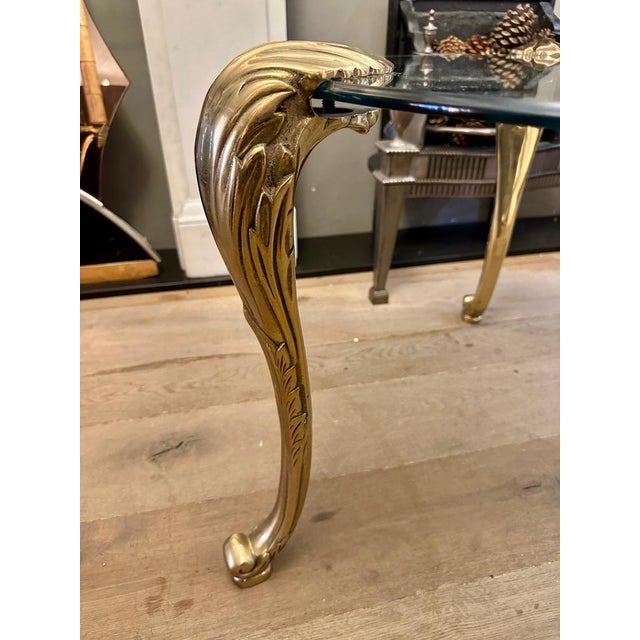 A Circular glass topped table with three scrolled Acanthus leaf supports. The glass top bevelled and original to piece. In...