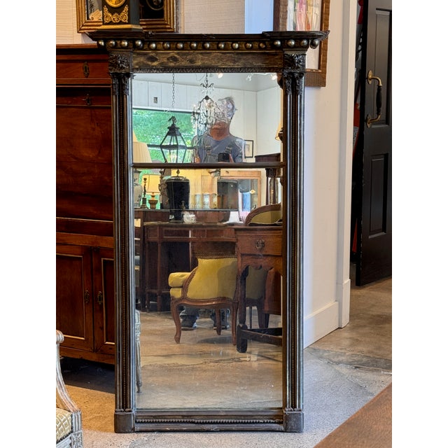 A tall and imposing 19th century giltwood pier mirror with a strong architectural presence. The broken pediment cornice is...